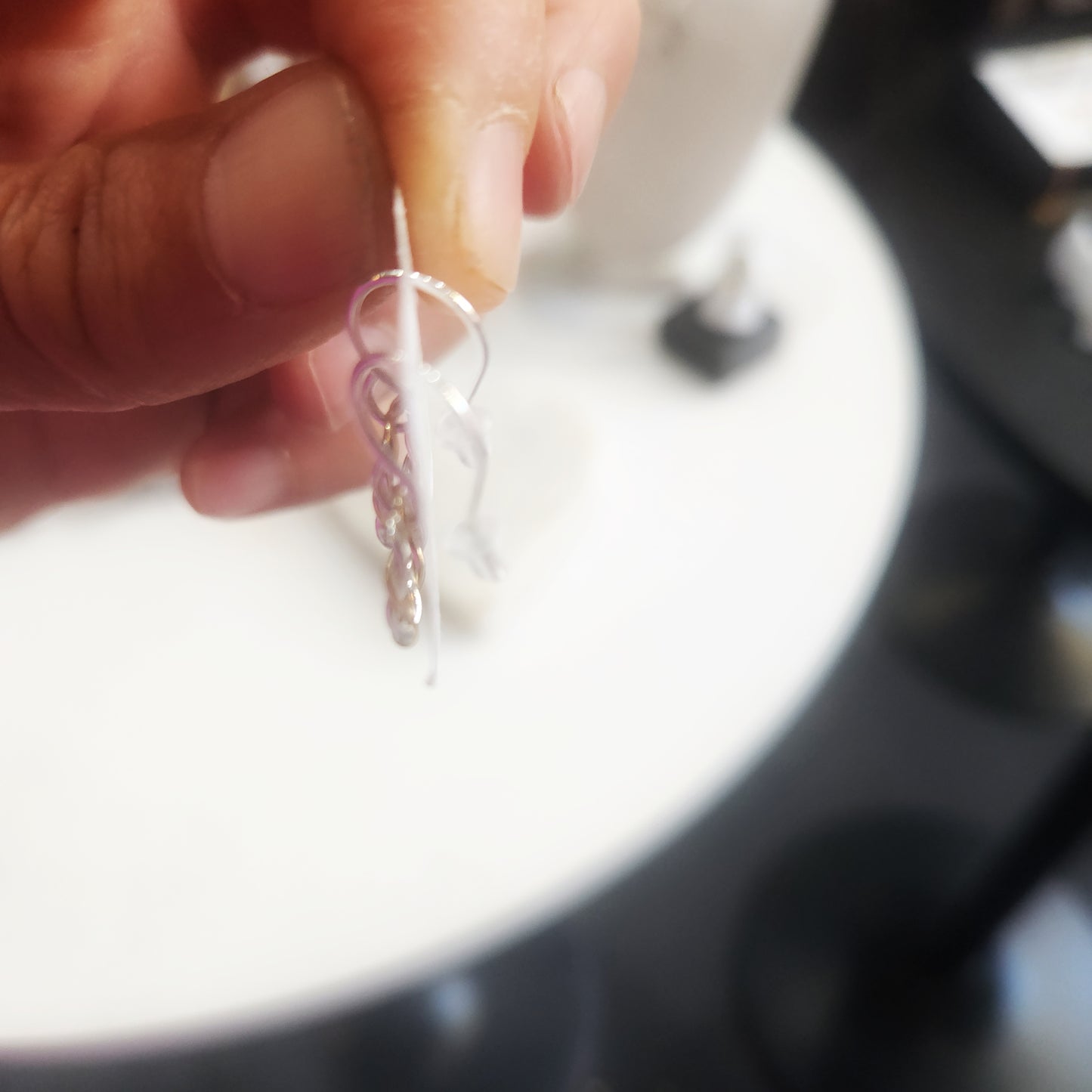 Close-up of handmade twisted hoop earrings in mixed metals held in hand
