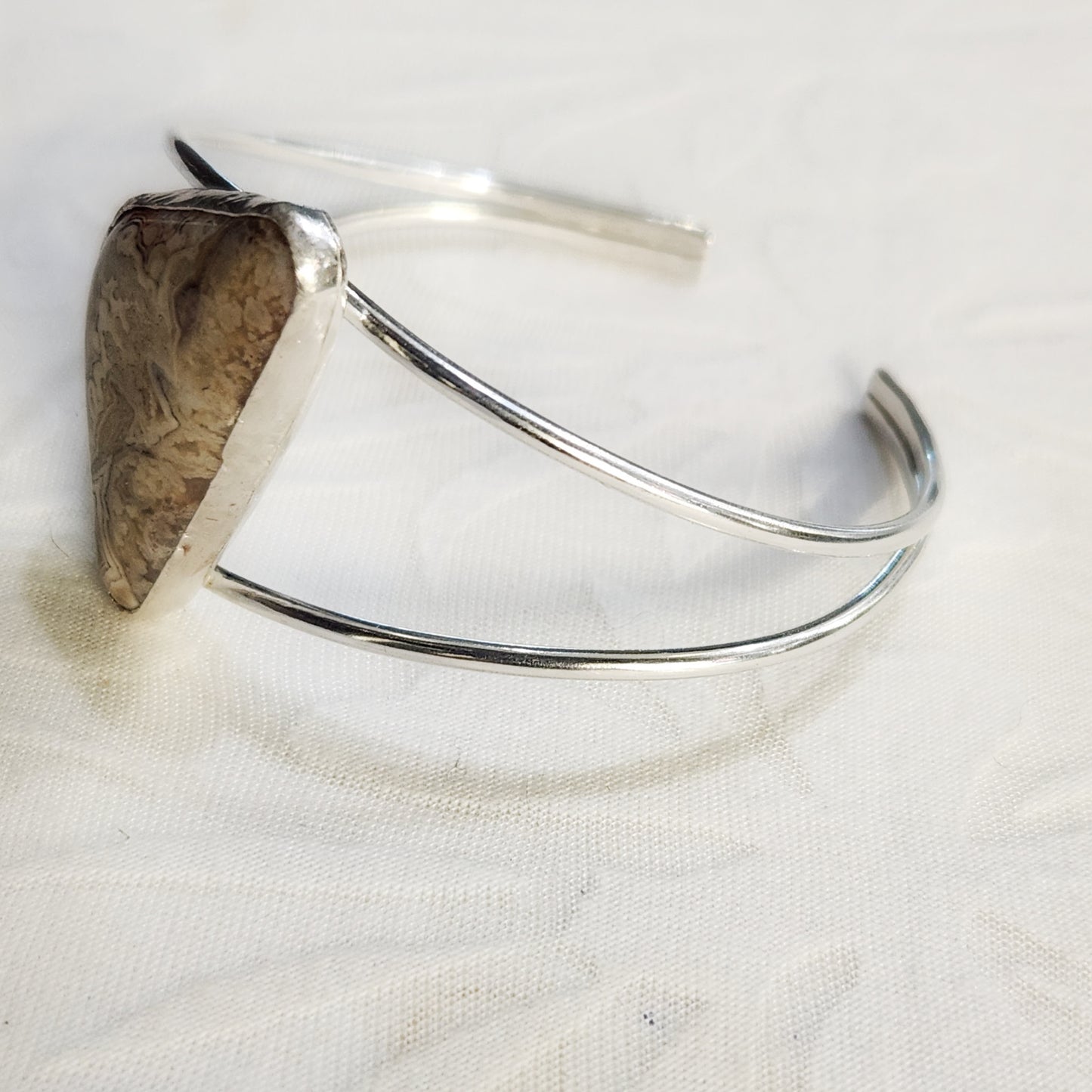 Crazy Lace Agate triangle stone cuff bracelet – angled side view showing stone details.