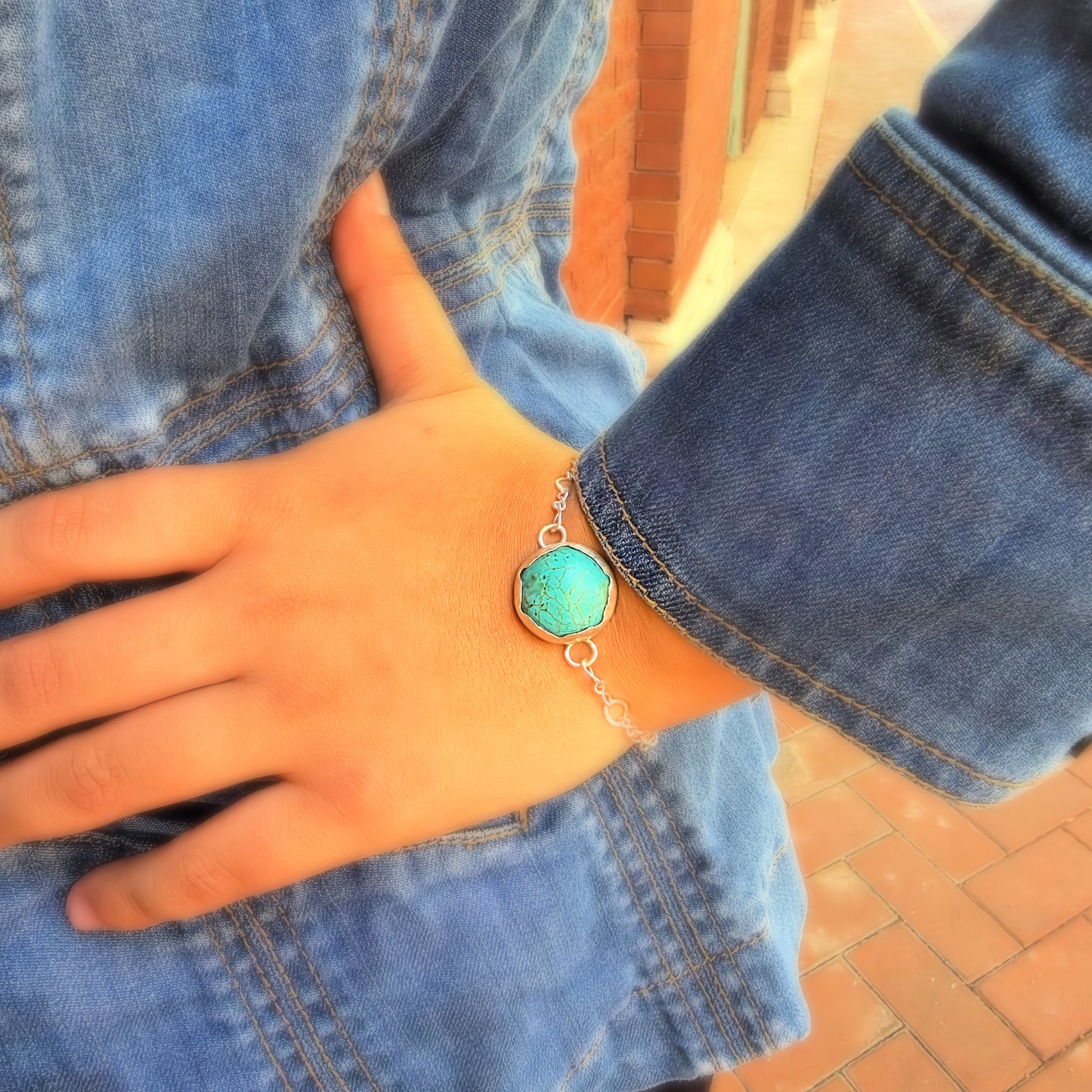 Woman wearing handmade Eternal Spirit Turquoise Bracelet with denim jacket.