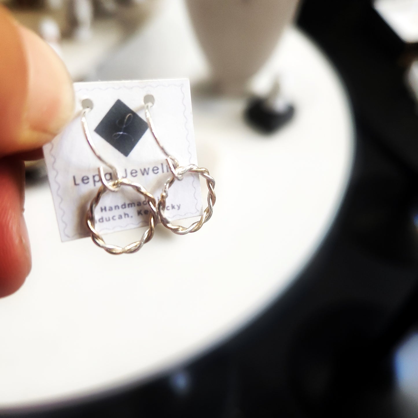 Dainty gold and silver twisted hoop earrings on Lepa Jewelry card