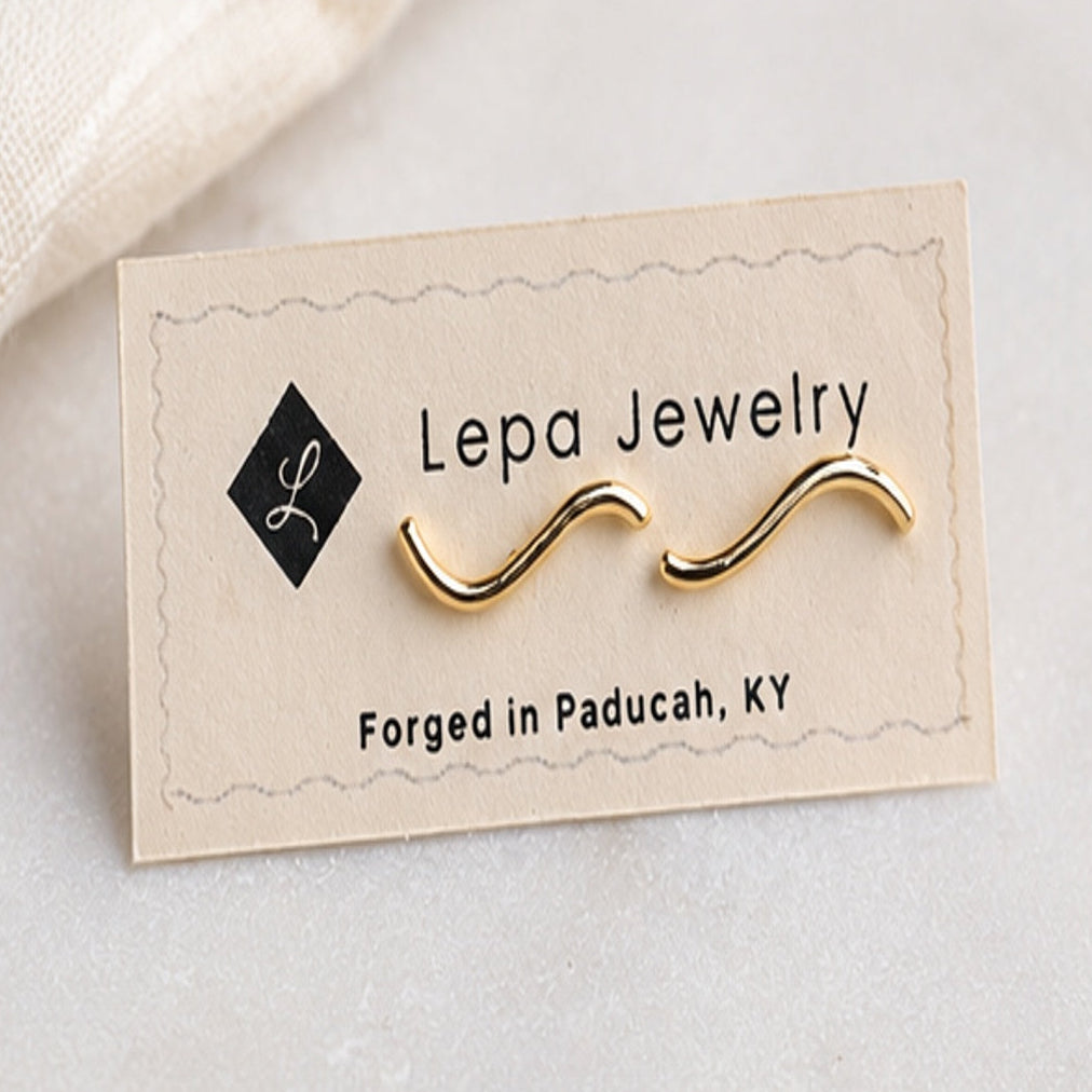 Minimalist wave stud earrings displayed on Lepa Jewelry card for size reference, forged in Paducah Kentucky