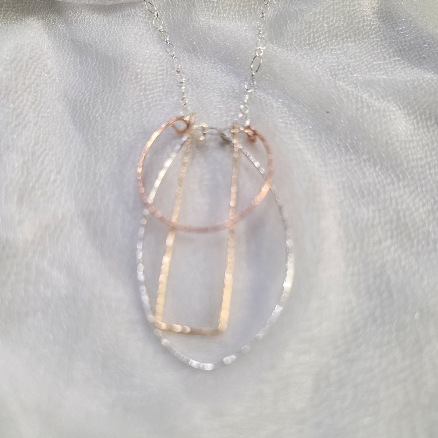 . Close-up of the Art Deco Necklace showing the Argentium Silver, Gold-Filled, and Rose Gold-Filled hammered geometric pendants