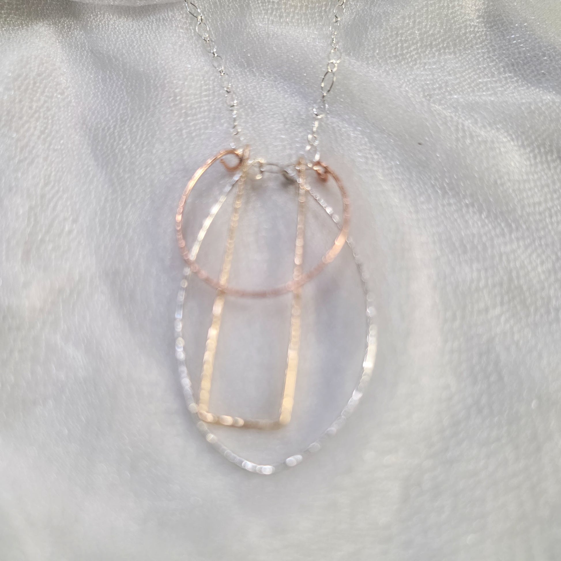 . Close-up of the Art Deco Necklace showing the Argentium Silver, Gold-Filled, and Rose Gold-Filled hammered geometric pendants