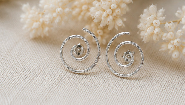 Silver spiral stud earrings with neutral floral styling, sculptural minimalist jewelry