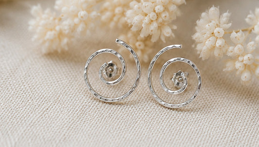 Silver spiral stud earrings with neutral floral styling, sculptural minimalist jewelry