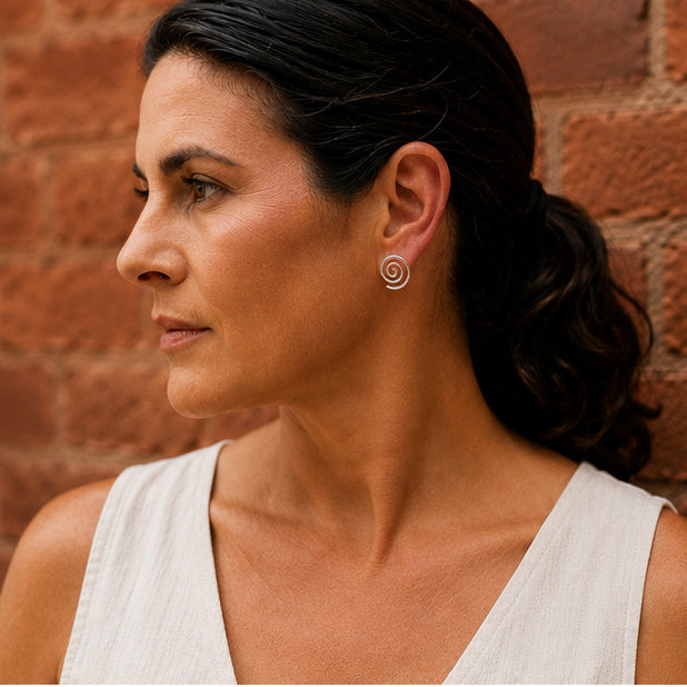 Silver spiral stud earrings worn on ear, Aurelia Studs in Argentium sterling silver by Lepa Jewelry