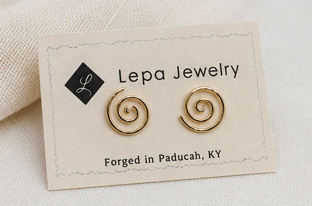 Gold spiral stud earrings displayed on Lepa Jewelry card, showing size and placement