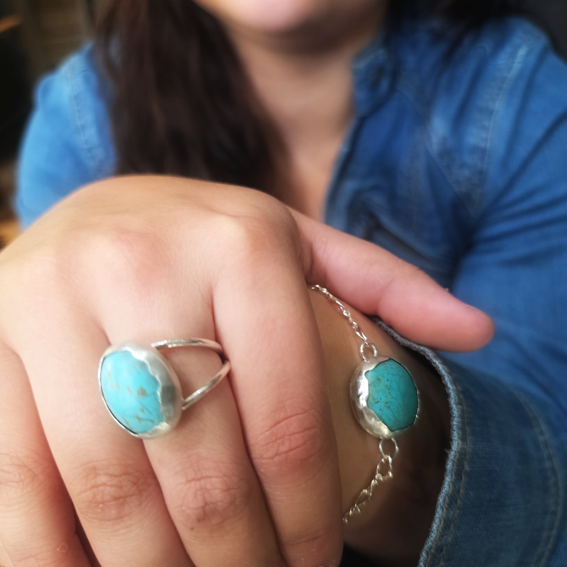 Matching turquoise ring and bracelet styled together on hand.