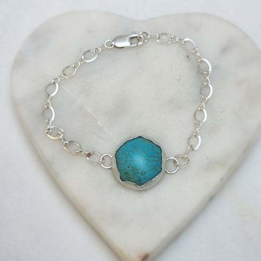 Eternal Spirit Turquoise Bracelet on white marble heart background.