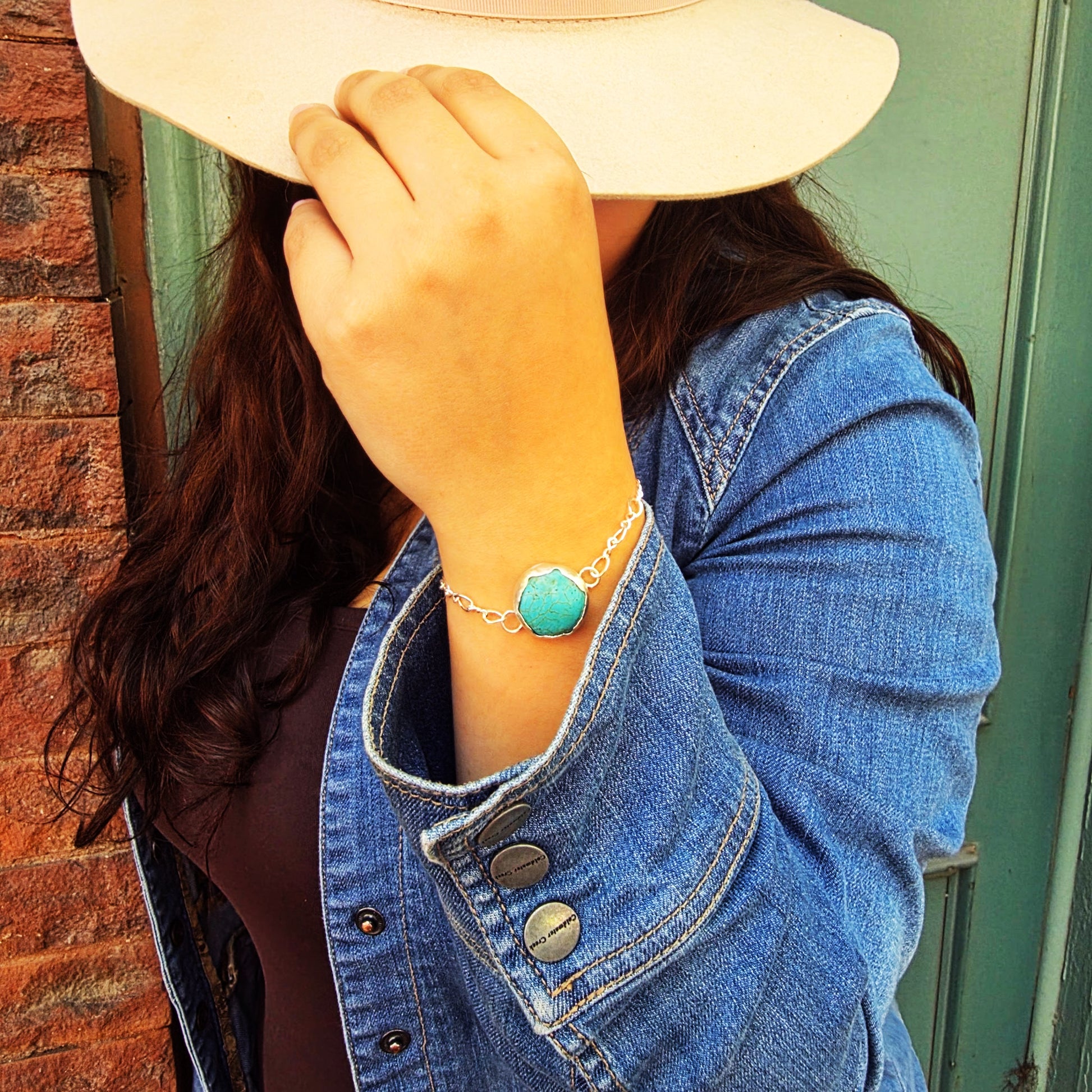 Lifestyle photo of woman wearing Eternal Spirit Bracelet with hat and denim jacket.