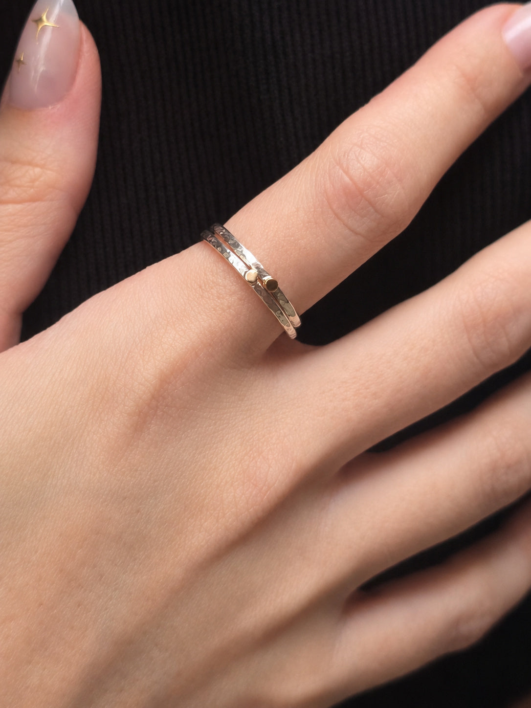 Two Golden Moment Rings stacked together on the finger, featuring hand-forged Argentium silver bands with solid 14k yellow gold accents.