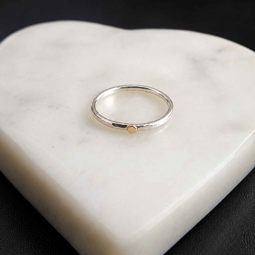 Two Golden Moment Rings stacked together on the finger, featuring hand-forged Argentium silver bands with solid 14k yellow gold accents.