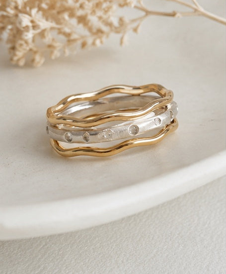 Trivera Ring Set flat lay showing all three bands — Argentium Silver center with Gold-Filled outer bands