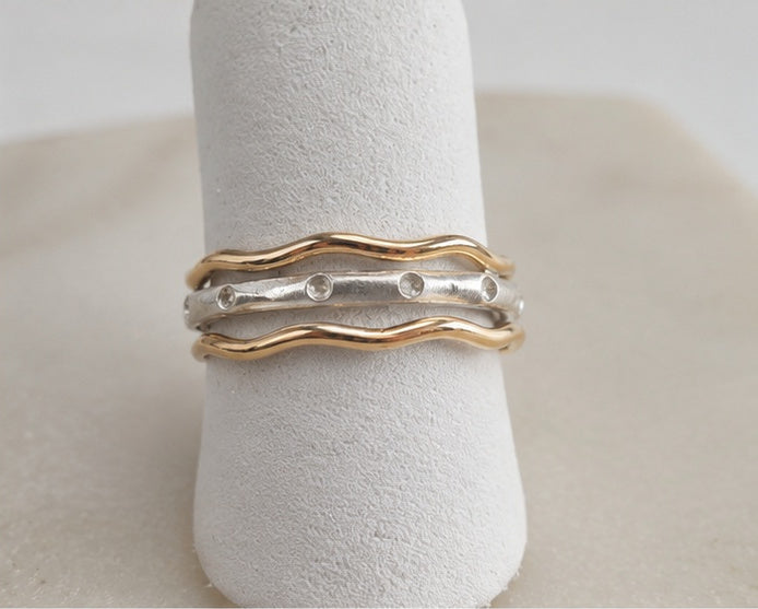 Close-up of Trivera Ring Set showing matte silver center band with sculpted impression detail
