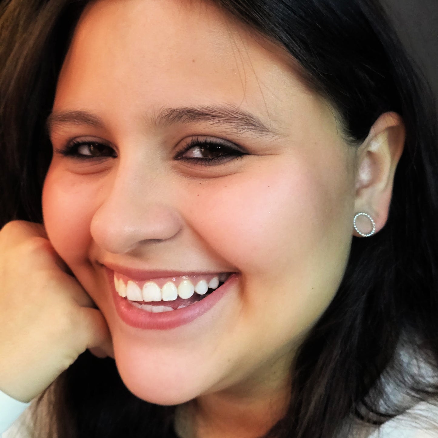 Close-up of a woman smiling with a neutral background