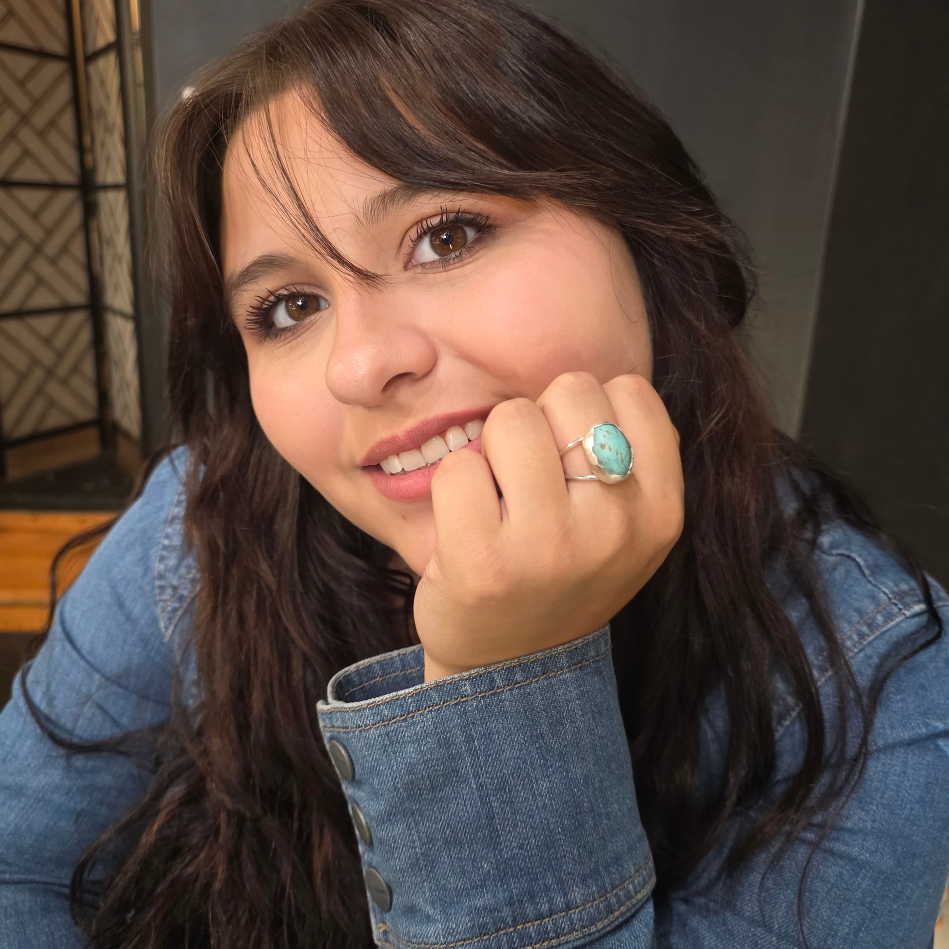 Smiling woman wearing turquoise statement ring.