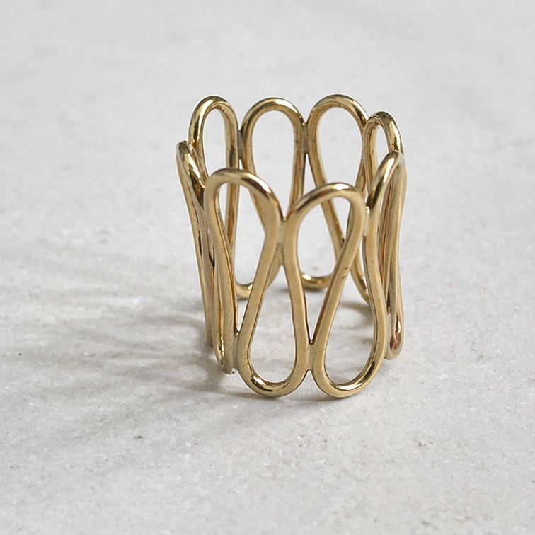 Aegis Ring by Lepa Jewelry, sculptural gold statement ring with flowing curved design on neutral stone surface