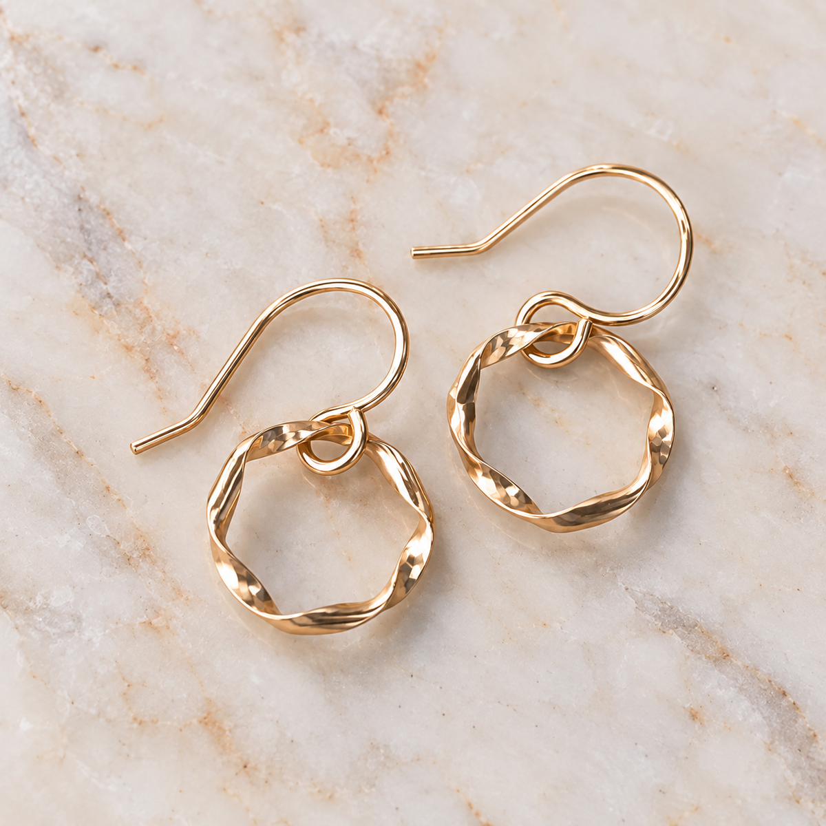 Close-up of sculptural gold-filled hoop earrings on marble surface, Strata Collection by Lepa Jewelry
