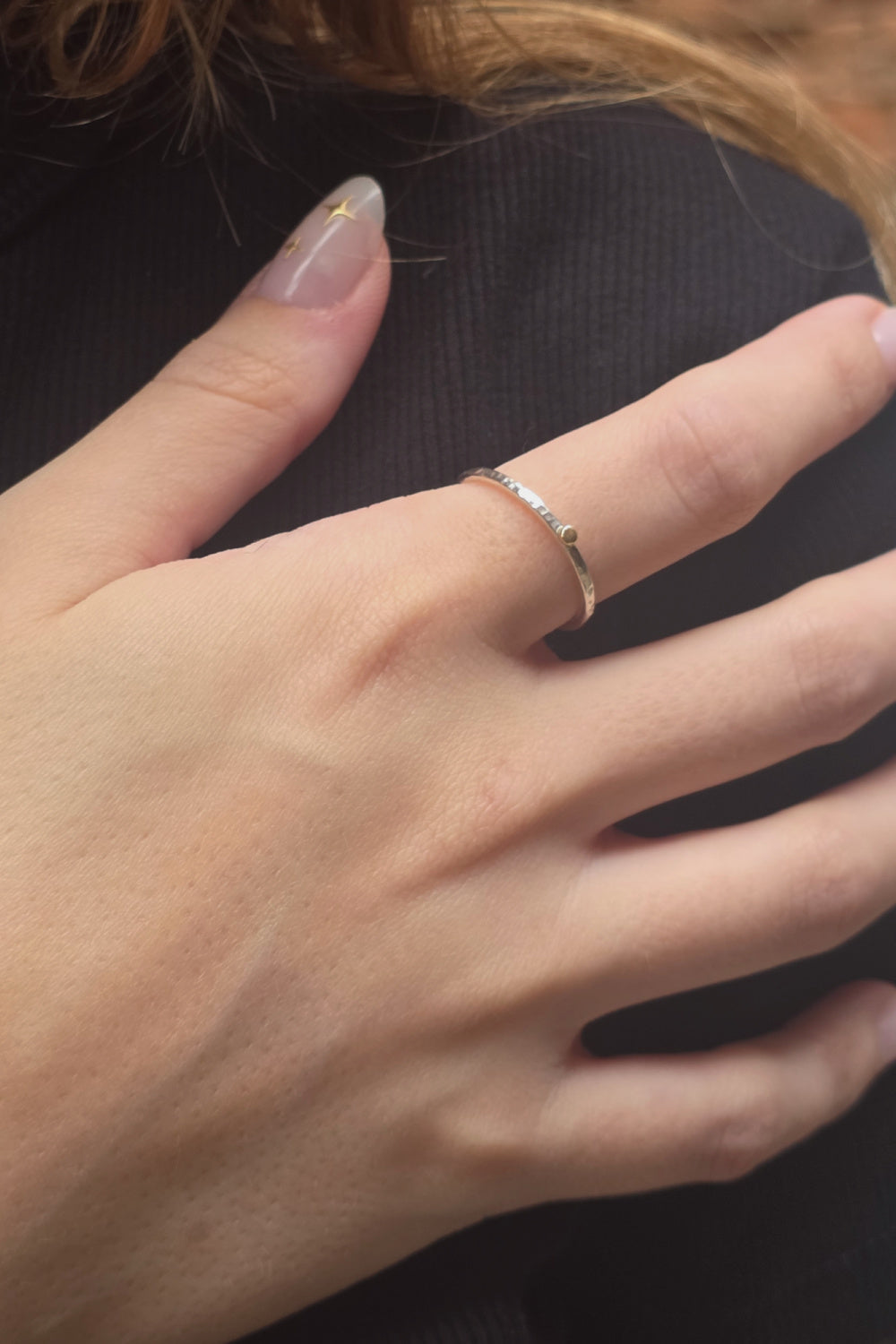 The Golden Moment Ring worn on the hand, showcasing its minimalist mixed-metal design and hand-hammered Argentium silver band.