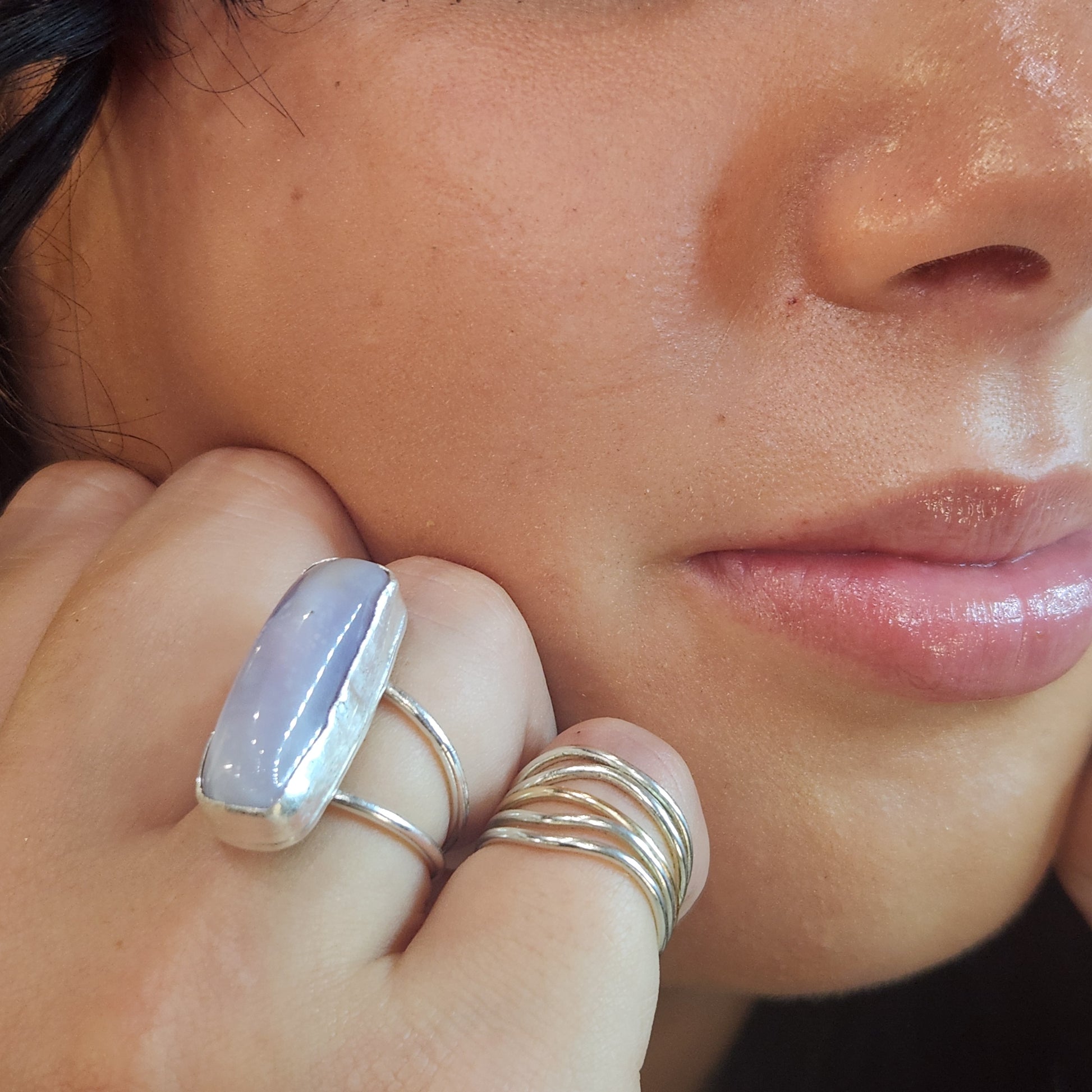 Lavender agate gemstone ring catching light at an angle to reveal subtle bands and calming color