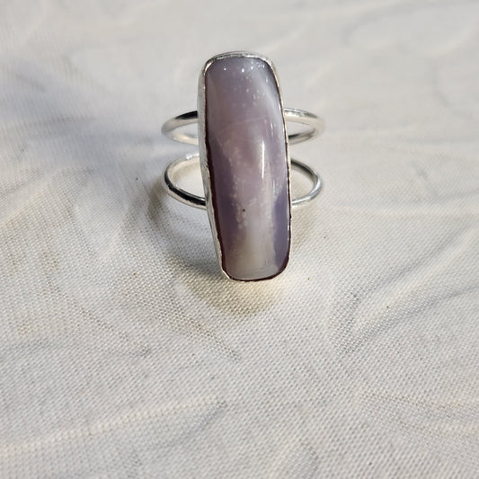Flat lay image of lavender agate power ring with soft background, emphasizing its silver craftsmanship