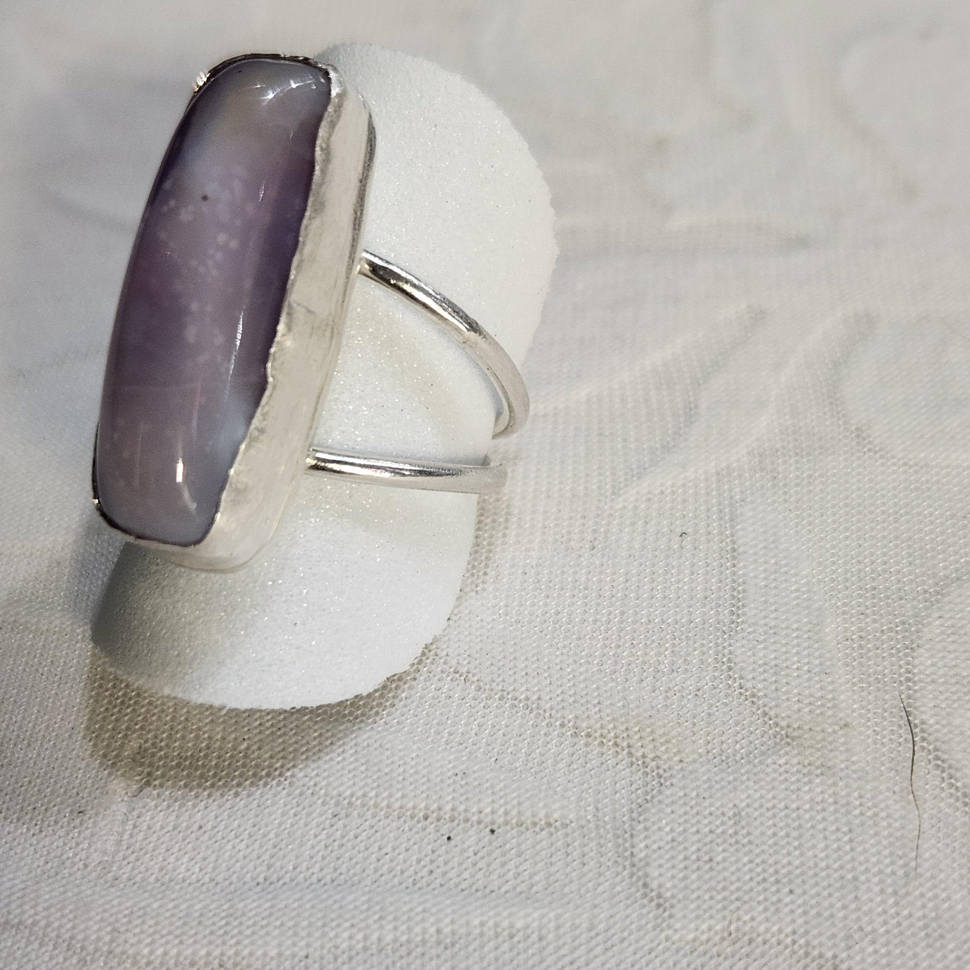 Zoomed-in image of natural lavender agate with light purple and lilac banding, polished to a smooth finish