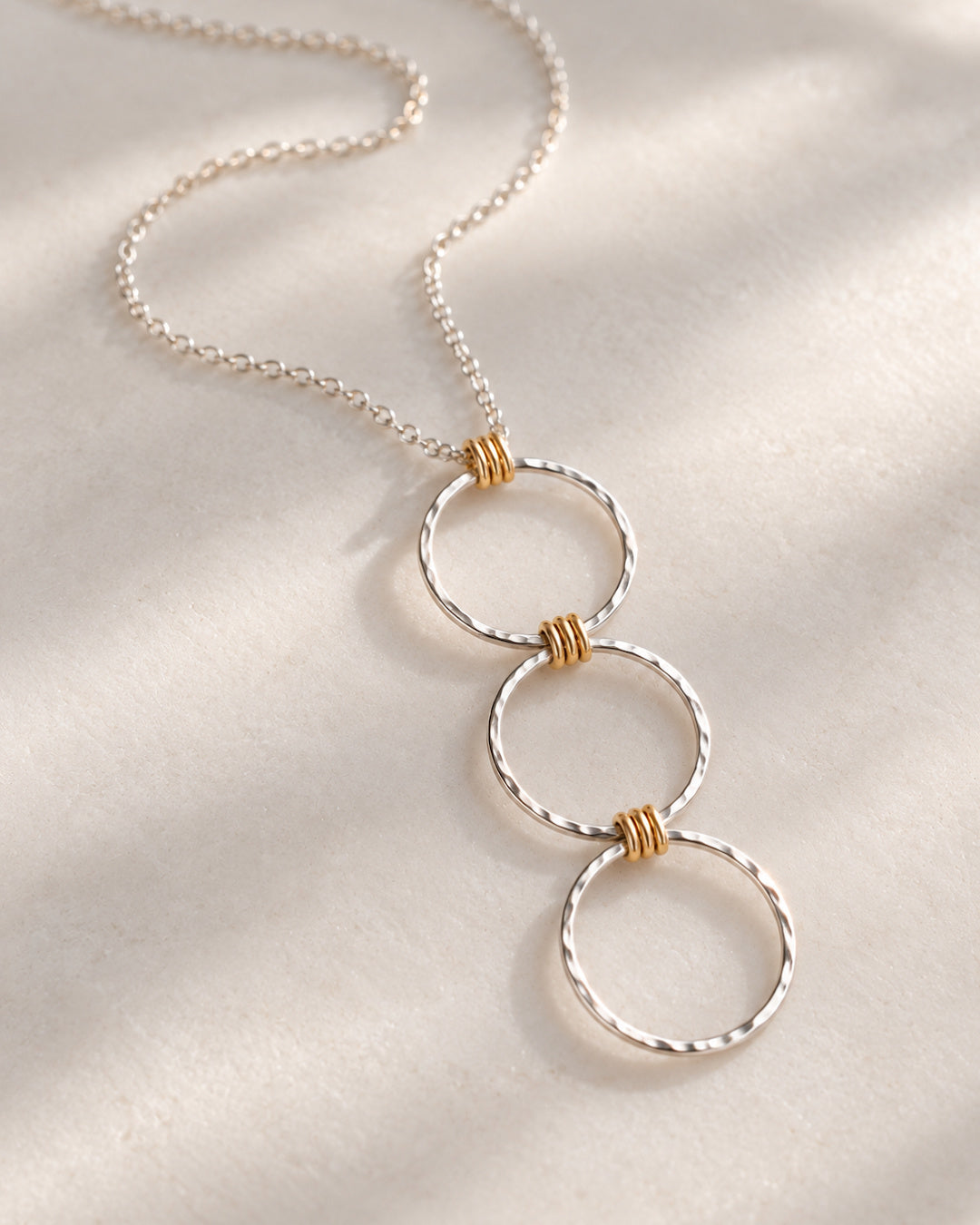 Argentium silver and gold-filled Linear Luxe Day Edition Necklace resting on a soft ivory surface