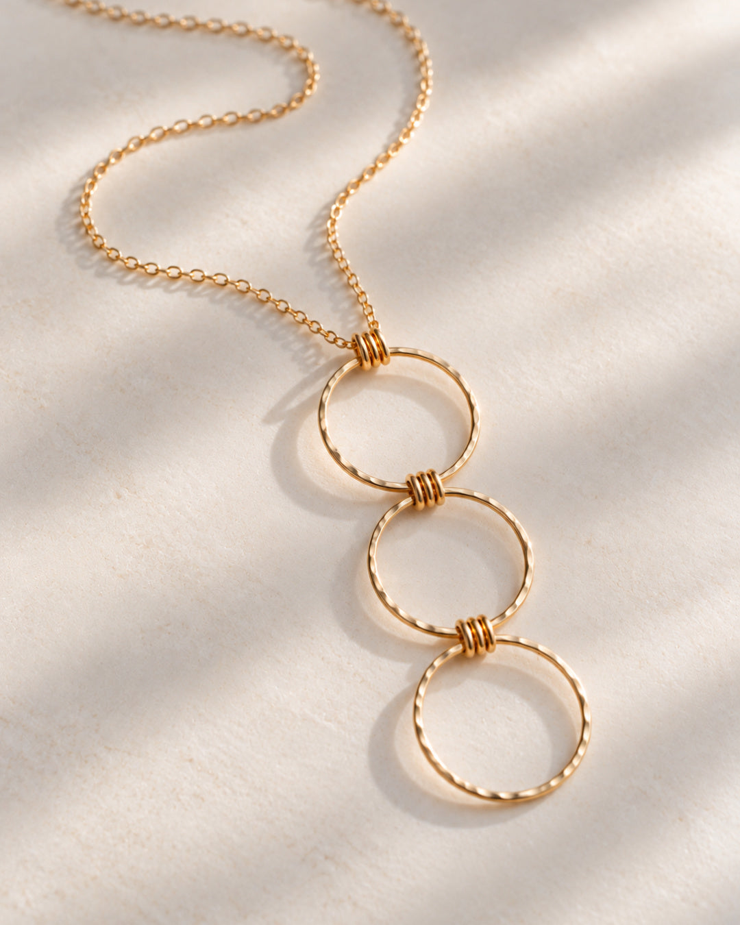 Gold-filled Linear Luxe Day Edition Necklace resting naturally on a soft ivory surface