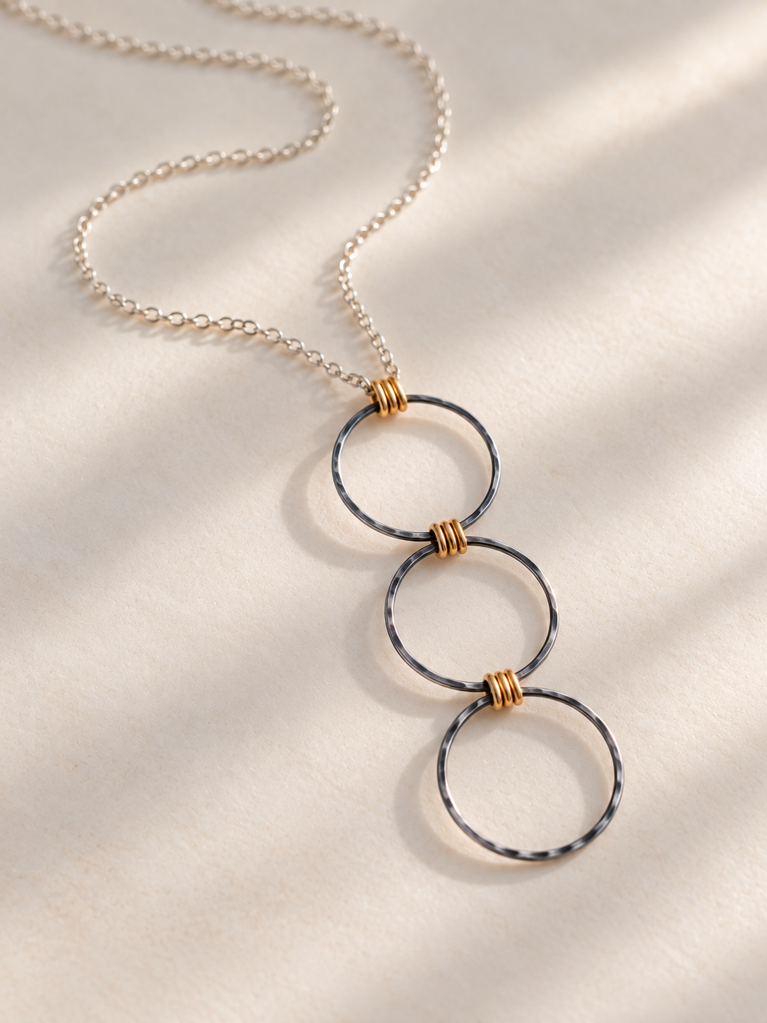 Oxidized Argentium silver and gold-filled Linear Luxe Day Edition Necklace resting on a soft ivory surface