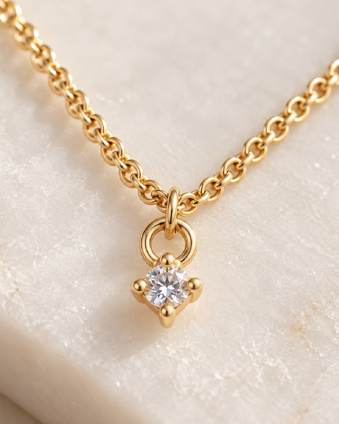 Close-up of the Sultry Drop Necklace showing a brilliant round cubic zirconia in a diamond-shaped gold-filled four-prong setting with delicate rolo chain.