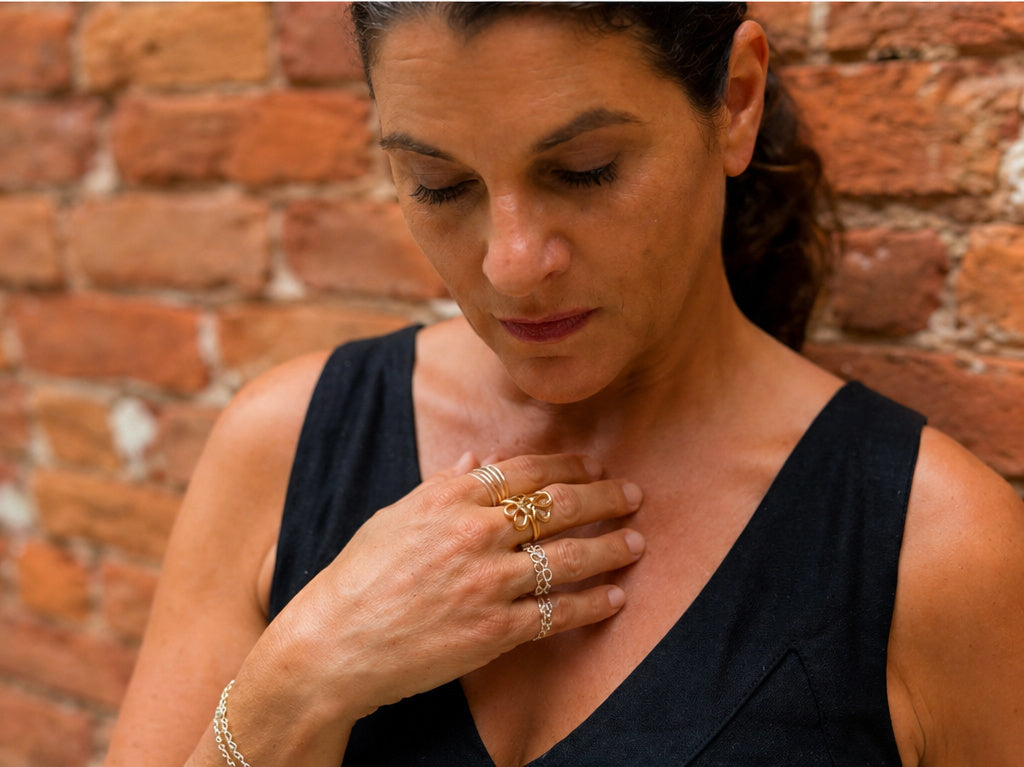 Wildflower Bloom statement ring in gold worn on model with layered rings, sculptural flower design by Lepa Jewelry